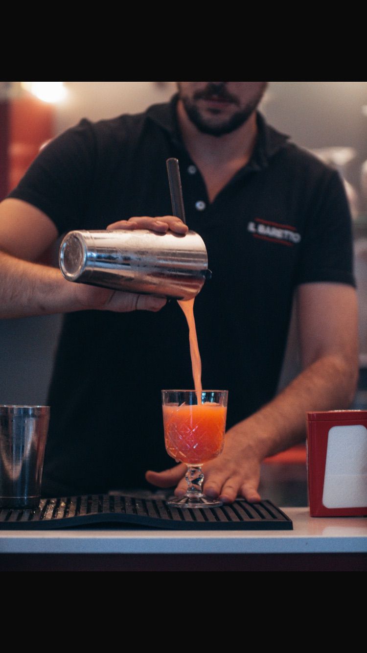 Barman al lavoro durante la preparazione di un cocktail a Como